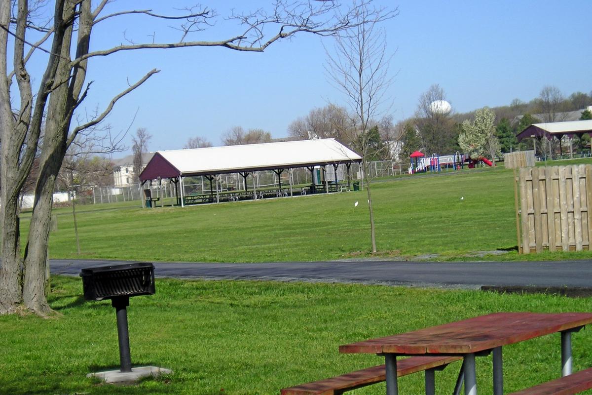 Large grassy area with pavilion in background